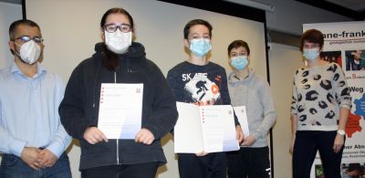 Abdullah Zeybek, stellvertretender Schulleiter der Anne-Frank-Schule, überreicht Ilayda Aka, Philipp Spitzner und Konstantinos Theofanopoulos (von links, es fehlt Miran Martinez) die Urkunden für den Mathewettbewerb. (Foto: afs)